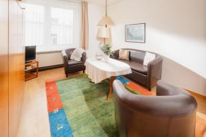 a living room with a couch and a table and chairs at Haus Tiemann Wohnung 7 in Norderney