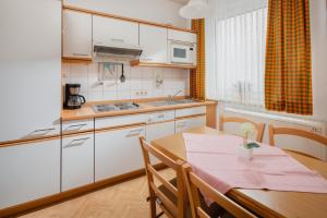 a kitchen with a wooden table and a dining room at Haus Tiemann Wohnung 7 in Norderney