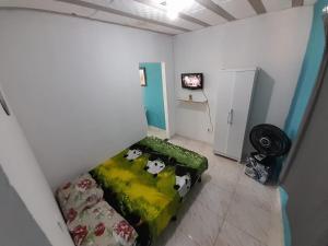 um pequeno quarto com uma cama com vacas em Kitnet Mobiliada Itaboraí em Itaboraí