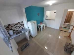 - une vue sur la cuisine équipée d'un réfrigérateur et d'une table dans l'établissement Kitnet Mobiliada Itaboraí, à Itaboraí