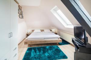 a small attic bedroom with a bed and a tv at Seepferdchen in der Villa Medici in Norderney