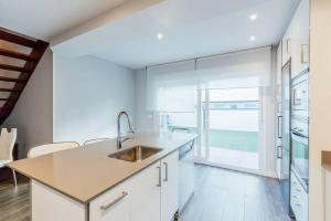 a kitchen with a sink and a large window at Chalet en la cuidad- con jardin y barbacoa in Gijón