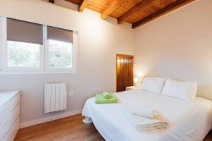 1 dormitorio con 1 cama blanca grande y toallas. en Chalet en la cuidad- con jardin y barbacoa en Gijón