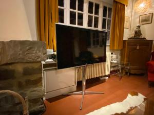 een grote flatscreen-tv in de woonkamer bij Les Barolins in Rotselaar