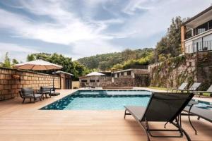 a swimming pool with chairs and tables and a building at La Fábrica #2 La Constancia in Valle de Bravo