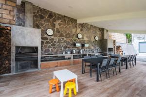 a kitchen with tables and chairs and a stone wall at La Fábrica #2 La Constancia in Valle de Bravo