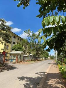 una calle vacía con árboles y un edificio en GCurtway Homes Nyayo 3 bedroom, en Nairobi