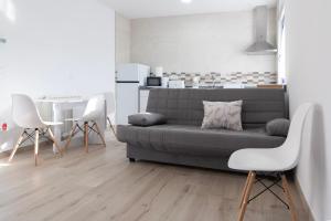 a living room with a gray couch and white chairs at Las casinas de Piedralba in Piedralba