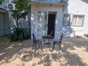 una mesa y sillas frente a una casa en Silken Trap Accommodation NO LOADSHEDDING en Johannesburgo