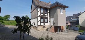 una casa blanca y marrón con una escalera delante en Zum Edelhof 24, en Homberg Ohm