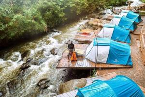 Un uomo su una zattera in un fiume con delle tende di Nyiak Tanjuang camp area 