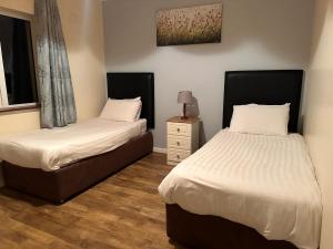 a bedroom with two beds and a night stand at Spanish Point Holiday Homes in Spanish Point