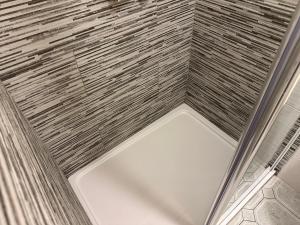 a shower with a white tub in a bathroom at Spanish Point Holiday Homes in Spanish Point