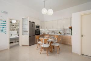 a kitchen and dining room with a table and chairs at Aphrodite's Luxury Pearls 2 in Pitsidia