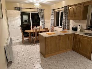 a kitchen with a table and a dining room at Spanish Point Holiday Homes in Spanish Point +9 photos
