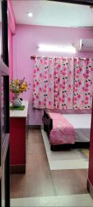 a bedroom with pink walls and a bed and a sink at Feel the Bong vibes in a villa nearest to airport. in Kolkata