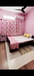 a bedroom with a large bed with pink walls at Feel the Bong vibes in a villa nearest to airport. in Kolkata