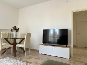 sala de estar con TV y mesa con sillas en Sferica en Campalto