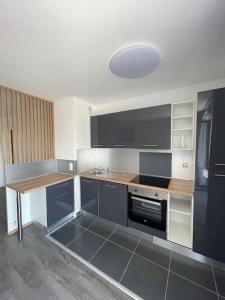 une cuisine avec des armoires en noir et blanc et une table dans l'établissement Appartement résidentiel Longjumeau, à Longjumeau
