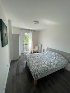 a bedroom with a bed in a room with a window at Appartement résidentiel Longjumeau in Longjumeau