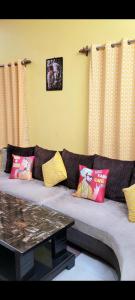 a living room with a couch with colorful pillows at Feel the Bong vibes in a villa nearest to airport. in Kolkata