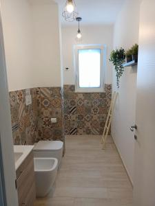 La salle de bains est pourvue de toilettes et d'une fenêtre. dans l'établissement Villa Colapesce, à Marzamemi