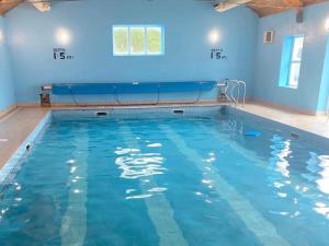 a swimming pool with blue walls and blue water at Spanish Point Holiday Homes in Spanish Point