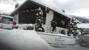 ein Haus ist mit Schnee bedeckt mit einem Zaun in der Unterkunft Ferienwohnung Partenkirchen in Garmisch-Partenkirchen