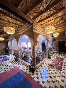 een grote lobby met een trap en kroonluchters bij Riad Tamdakhte in Aït Ben Haddou