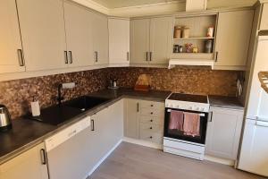 a kitchen with white cabinets and a sink at Private Mountain House with Spectacular Views in Narvik