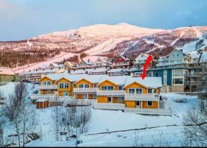 un resort en la nieve con una montaña en el fondo en Private Mountain House with Spectacular Views, en Narvik