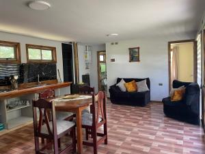 cocina y sala de estar con mesa y sillas en Cabaña Curacautín “Refugio Cautin”, en Curacautín