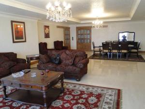 Zamalek Retreat: Premium Stay with Nile View في القاهرة: غرفة معيشة مع كنب وغرفة طعام