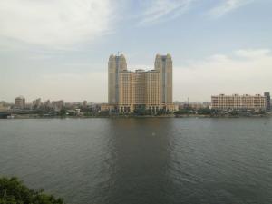 Zamalek Retreat: Premium Stay with Nile View في القاهرة: مجموعة كبيرة من المياه مع المباني في الخلفية