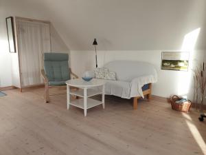 a living room with a couch and a table and a chair at SKAU Beach View in Aabenraa