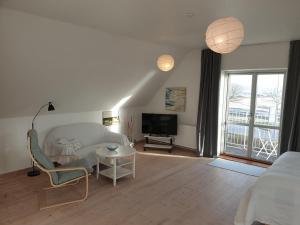 a bedroom with a bed and a tv and a table at SKAU Beach View in Aabenraa