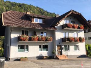 a building with flower boxes on its windows at Appartement Kuhglocken Ferienhaus Fuenf Sinne in Döbriach