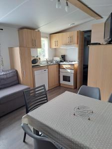 een keuken en een woonkamer met een tafel en stoelen bij GH Vacances La Réserve in Gastes