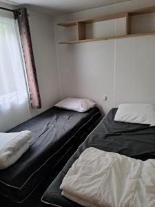 twee bedden in een kamer met een raam bij GH Vacances La Réserve in Gastes