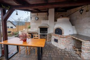 a outdoor patio with a pizza oven with a table at Völgy Villa in Zebegény