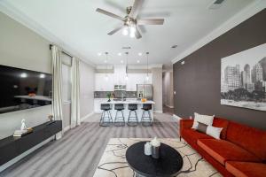 ein Wohnzimmer mit einem roten Sofa und einer Küche in der Unterkunft Pet OK, 10 min to Alphaland, Home Gym, Gated in Houston