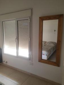 ein Schlafzimmer mit einem Spiegel und einem Bett darin in der Unterkunft Las Ballenas Casas de Playa - frente al mar in Monte Hermoso