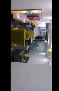 a lego kitchen with yellow chairs and stairs at Mega Pavilion Apartment And Suits Gwarinpa in Gwarinpa