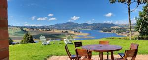 a table and chairs with a view of a lake at Mágica CASA FINCA represa del Sisga wi-fi, tv, BBQ in Chocontá