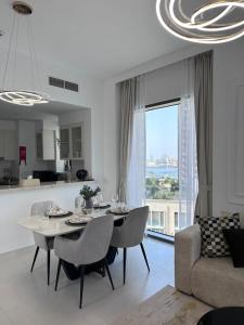 a dining room and living room with a table and a couch at Creek Harbour retreat: Luxurious 2-BR apartment in Dubai