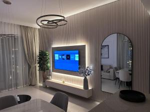 a living room with a flat screen tv on a wall at Creek Harbour retreat: Luxurious 2-BR apartment in Dubai