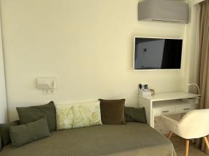 uma sala de estar com um sofá e uma televisão de ecrã plano em Las Palmas 1 em Marbella
