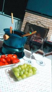 una mesa con dos copas de vino y un tazón de fruta en Chalés Canton Suisse, en Nova Friburgo