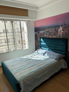 une chambre avec un lit avec un tableau sur le mur dans l'établissement Charmant appart 2 chamb+salon au cœur de la ville!, à Rabat