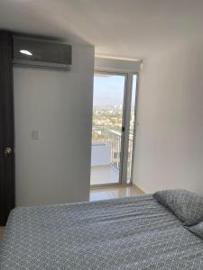 Schlafzimmer mit einem Bett und Blick auf einen Balkon in der Unterkunft Comodo Apartamento Cartagena in Cartagena de Indias